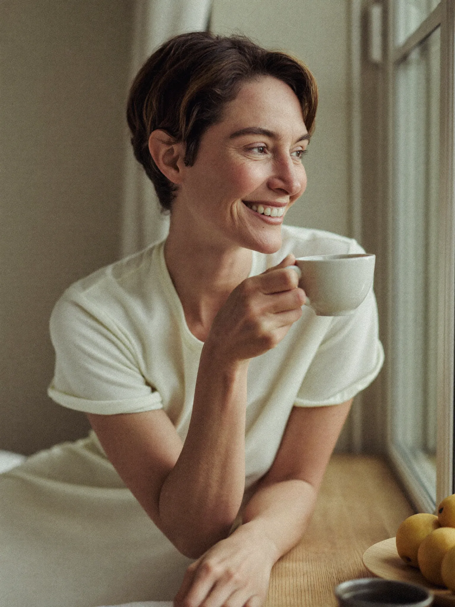 A woman waking rested and calm by a window